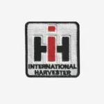 Embroidered iron-on patch featuring the International Harvester "IH" logo in black and red on a white background, with the words "INTERNATIONAL HARVESTER" below.