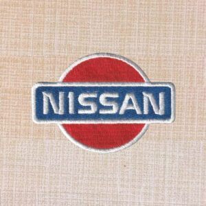 Nissan logo embroidered iron-on patch in silver, black, and red for automotive apparel.