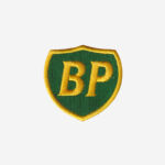 BP logo embroidered iron-on patch in green and yellow on denim surface with merrowed edge